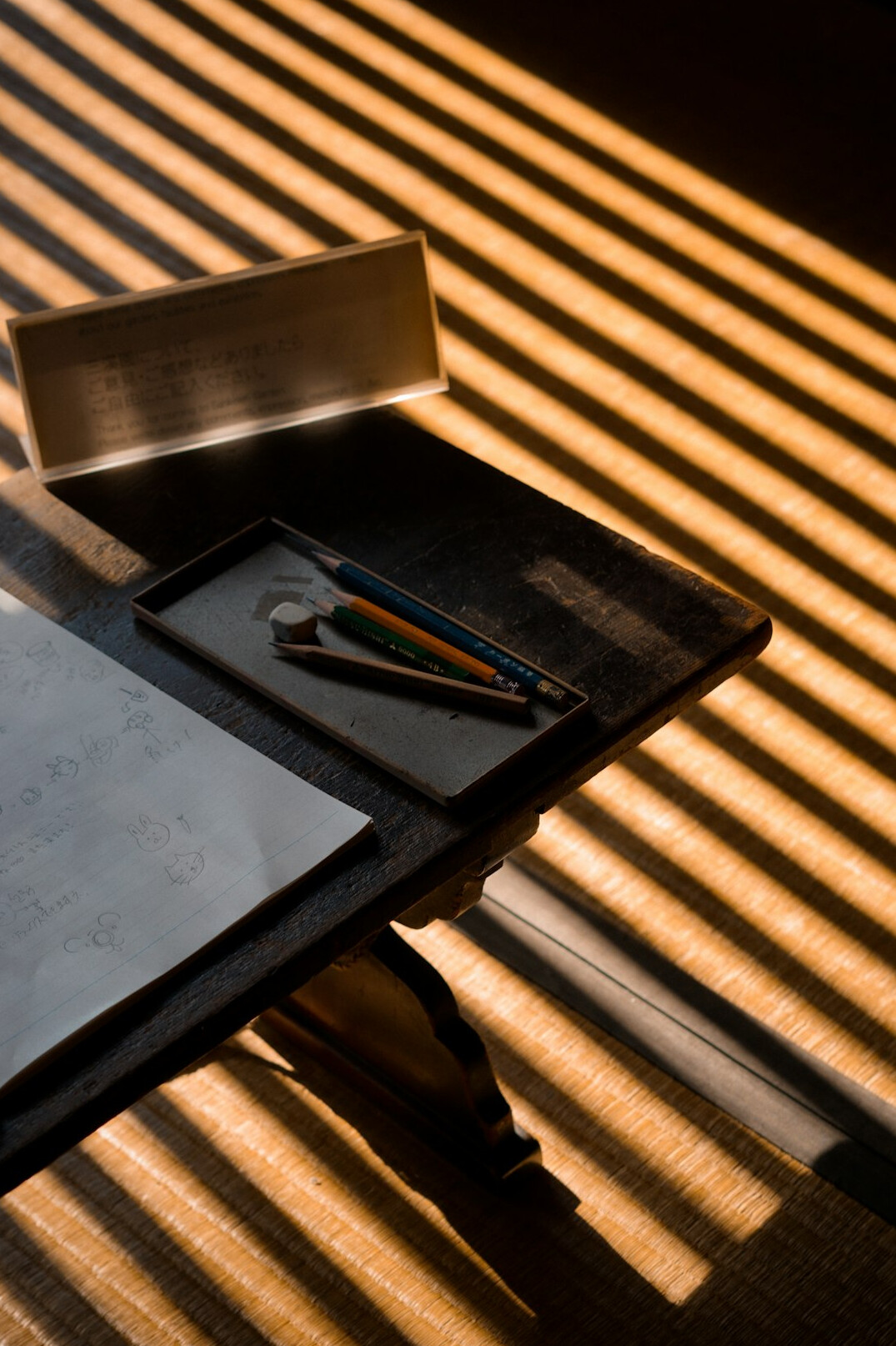 Close-up of a hand writing notes next to a laptop